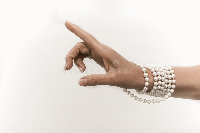 Pearl necklace on senior woman hand cut out on white background. Luxury jewelry on female hand with French manicure