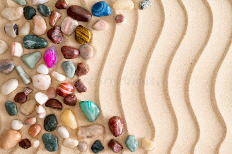 Pebbles and gemstones on golden beach sand