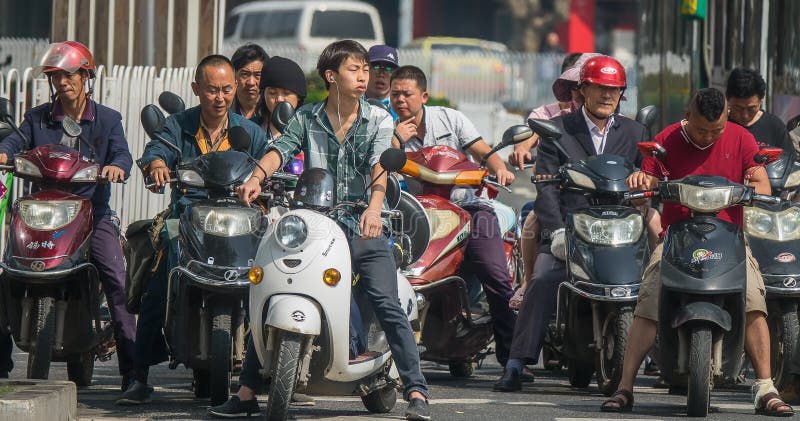 PECHINO/CINA 30 LUGLIO 2017: La gente sui motorini che aspettano i semafori nella città di Pechino Soltanto alcuna gente dura immagine stock PECHINO/CINA 30 LUGLIO 2017: La gente sui motorini che aspettano i semafori nella città di Pechino Soltanto alcuna gente dura immagine stock