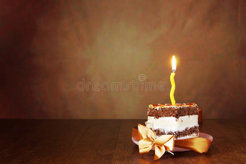 Pedazo de torta de chocolate del cumpleaños con una vela ardiente fotos de archivo Pedazo de torta de chocolate del cumpleaños con una vela ardiente fotos de archivo