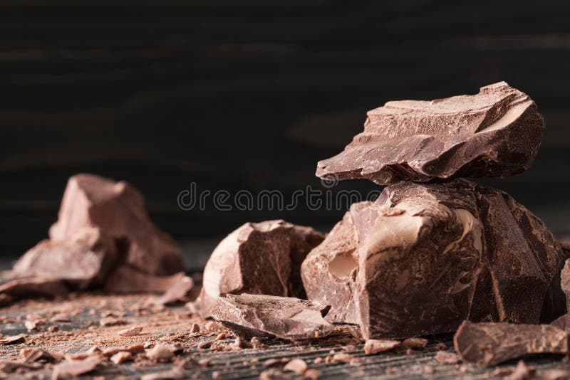 Pedazos del chocolate en un backround oscuro fotografía de archivo Pedazos del chocolate en un backround oscuro fotografía de archivo