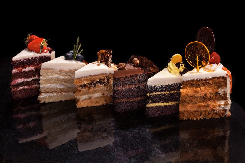 Pedazos grandes clasificados de diversas tortas: chocolate, frambuesas, fresas, nueces, arándanos Pedazos de tortas en a fotos de archivo Pedazos grandes clasificados de diversas tortas: chocolate, frambuesas, fresas, nueces, arándanos Pedazos de tortas en a fotos de archivo