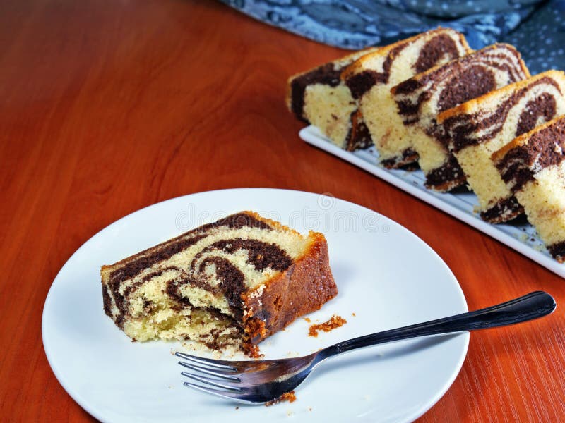 Pedaços de mármore de chocolate em prato branco com uma peça já comida imagens de stock Pedaços de mármore de chocolate em prato branco com uma peça já comida imagens de stock
