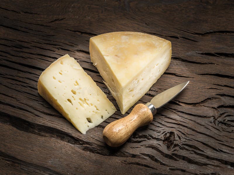 Pedaços de queijo caseiro sobre um fundo de madeira imagens de stock