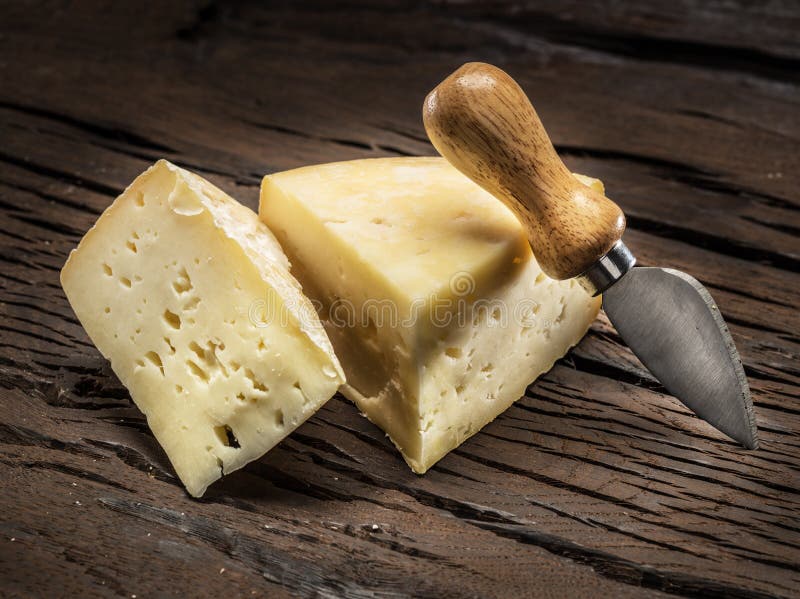 Pedaços de queijo caseiro sobre um fundo de madeira foto de stock royalty free