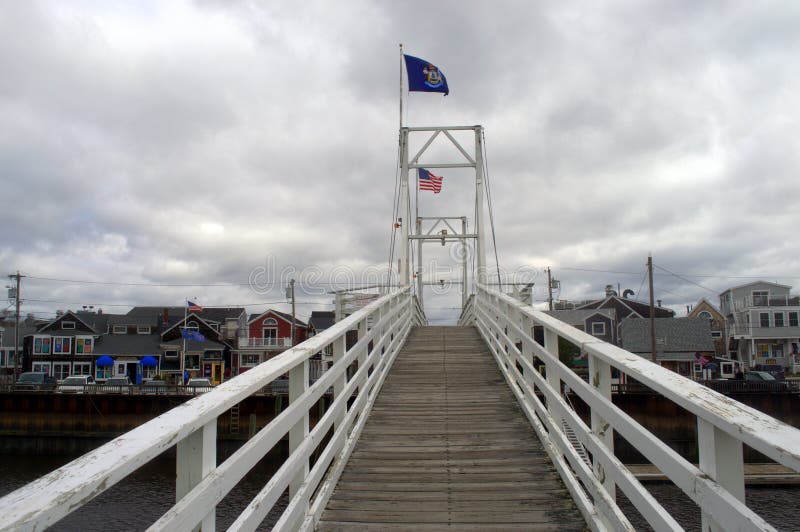 This photo was taken at Perkins Cove Maine.  This drawbridge and  footbridge is pedestrian operated.  This means anyone standing on the bridge when a boat needs to pass through can press the button making the bridge go up to let the boat through.  However, they don`t want any kids operating the controls.

The bridge connects the Kennebunk River and the Atlantic Ocean. This photo was taken at Perkins Cove Maine.  This drawbridge and  footbridge is pedestrian operated.  This means anyone standing on the bridge when a boat needs to pass through can press the button making the bridge go up to let the boat through.  However, they don`t want any kids operating the controls.

The bridge connects the Kennebunk River and the Atlantic Ocean.