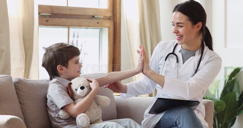 Pediatra feliz doctor animando a un niño en edad preescolar.