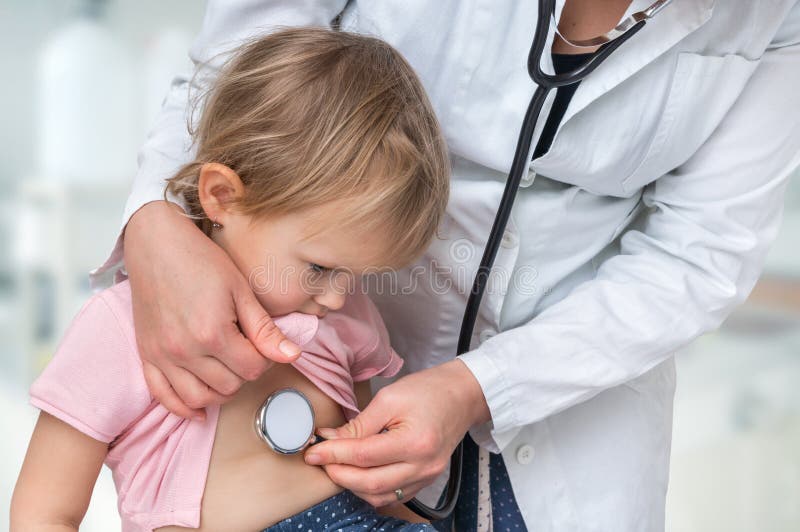 Pediatrician doctor examining a little girl by stethoscope royalty free stock photo Pediatrician doctor examining a little girl by stethoscope royalty free stock photo