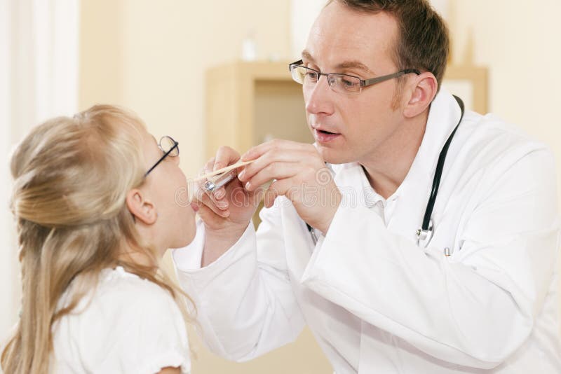 Pediatrician doctor examining throat of girl royalty free stock photography Pediatrician doctor examining throat of girl royalty free stock photography