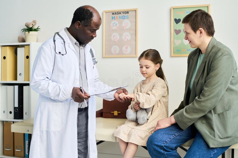 Pediatrician Examining Child in Doctor& x27;s Office Setting stock photos