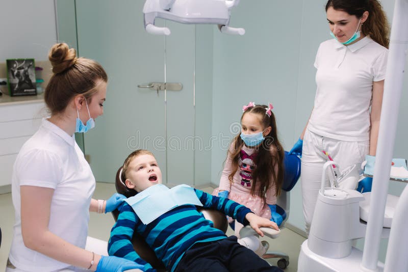 Pediatrische tandarts met medewerker met weinig jongen en meisje stock foto's Pediatrische tandarts met medewerker met weinig jongen en meisje stock foto's