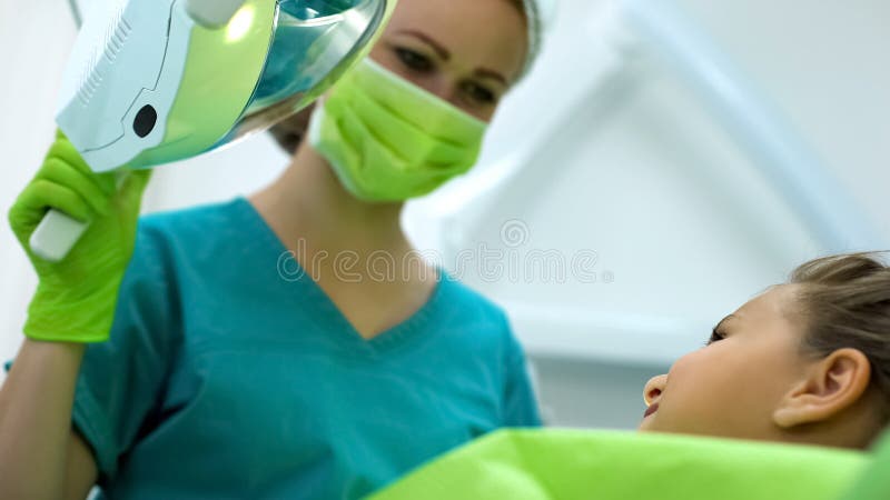 Pediatryczny dentysta ono uśmiecha się nastoletnia dziewczyna, odważna cierpliwa czekać na procedura zdjęcia royalty free Pediatryczny dentysta ono uśmiecha się nastoletnia dziewczyna, odważna cierpliwa czekać na procedura zdjęcia royalty free