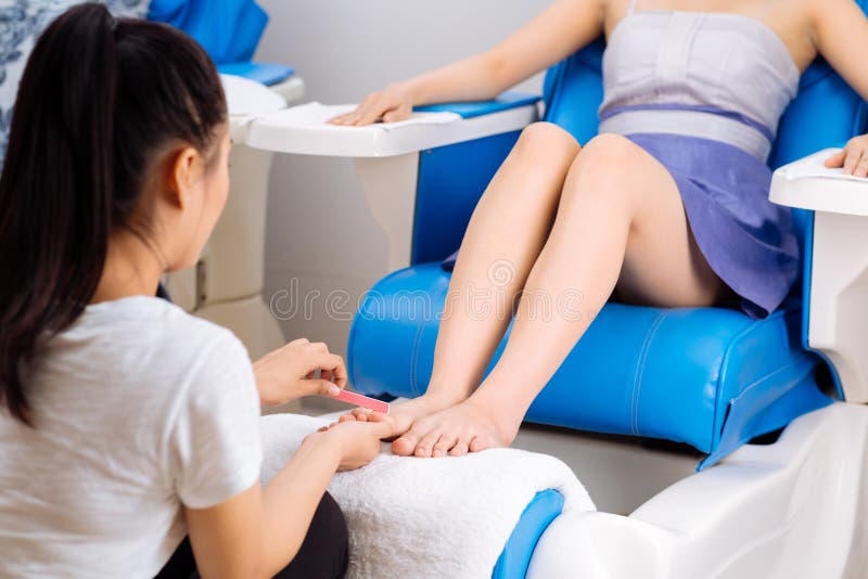 Woman having pedicure procedure in spa salon