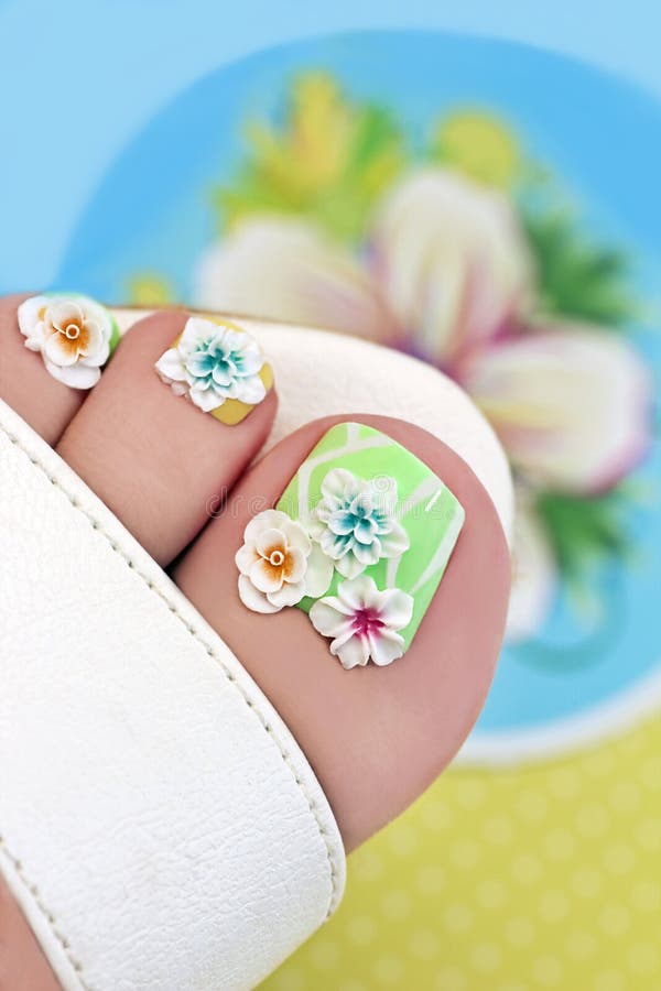 Summer flower pedicure with decorative flowers and different shades of lacquer on the women's feet. Summer flower pedicure with decorative flowers and different shades of lacquer on the women's feet.