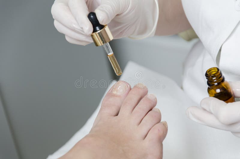 Close up hand brush drawing funny face on feet children with painted toes.  Baby art therapy