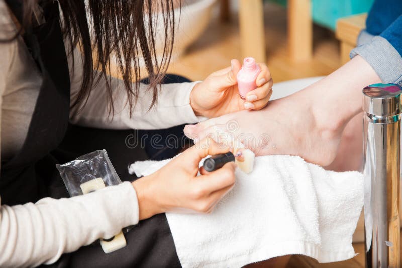 Pedikiurzysta stosuje gwóźdź poleruje niektóre toenails zdjęcie royalty free Pedikiurzysta stosuje gwóźdź poleruje niektóre toenails zdjęcie royalty free