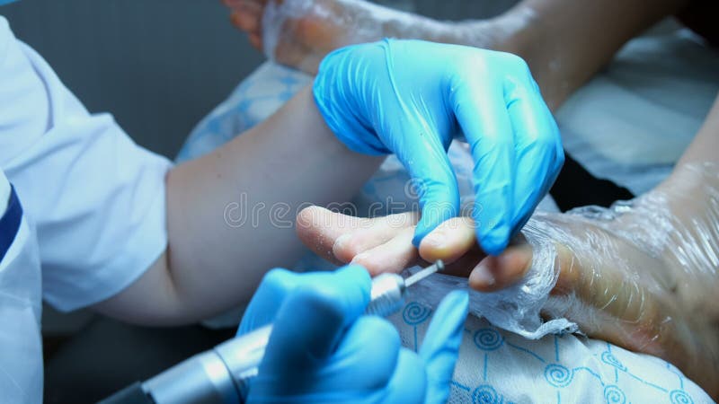 Pedikiurzysta wykonuje fachowych pedicure'u i połysk gwoździe obrazy royalty free Pedikiurzysta wykonuje fachowych pedicure'u i połysk gwoździe obrazy royalty free