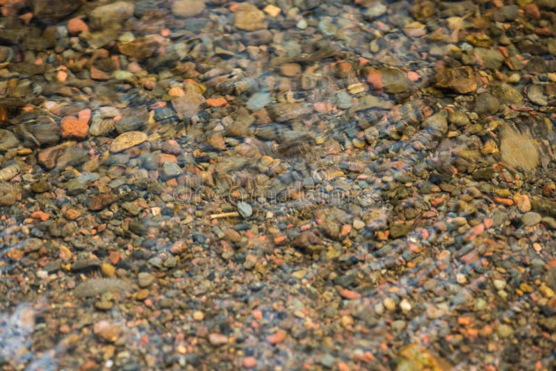 Pedras da vista superior no rio Os fundos da água da vegetação rasteira da rocha Pedras pequenas do seixo nas angras imagens de stock Pedras da vista superior no rio Os fundos da água da vegetação rasteira da rocha Pedras pequenas do seixo nas angras imagens de stock