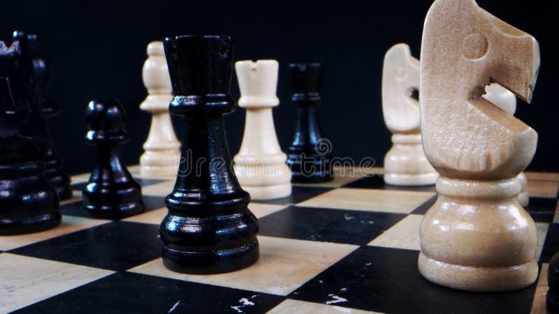 Mão jogando xadrez com peões preto e brancos