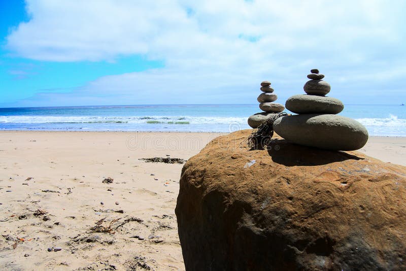Pedras do monte de pedras equilibradas na frente do oceano imagem de stock Pedras do monte de pedras equilibradas na frente do oceano imagem de stock