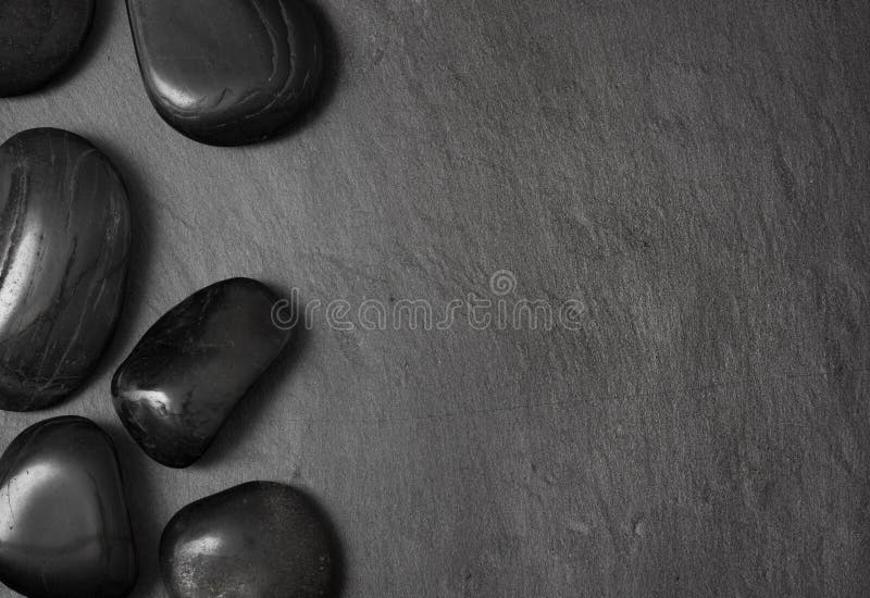 Pedras pretas da massagem da lava no fundo escuro fotografia de stock royalty free Pedras pretas da massagem da lava no fundo escuro fotografia de stock royalty free