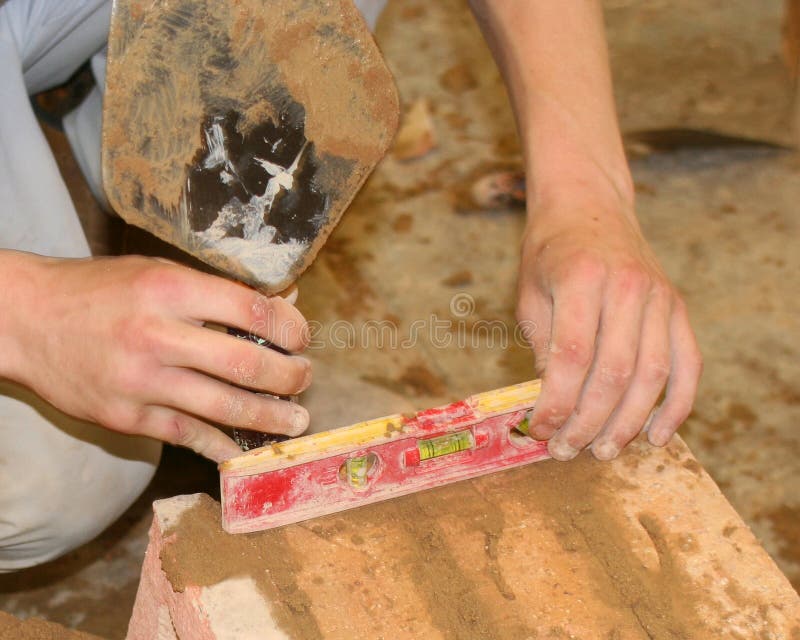 Bricklayer using spirit level. Bricklayer using spirit level