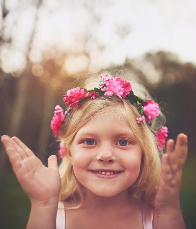 Peek a boo. a happy little girl smiling and looking at the camera after she opened her eyes playing hide and seek outside in nature