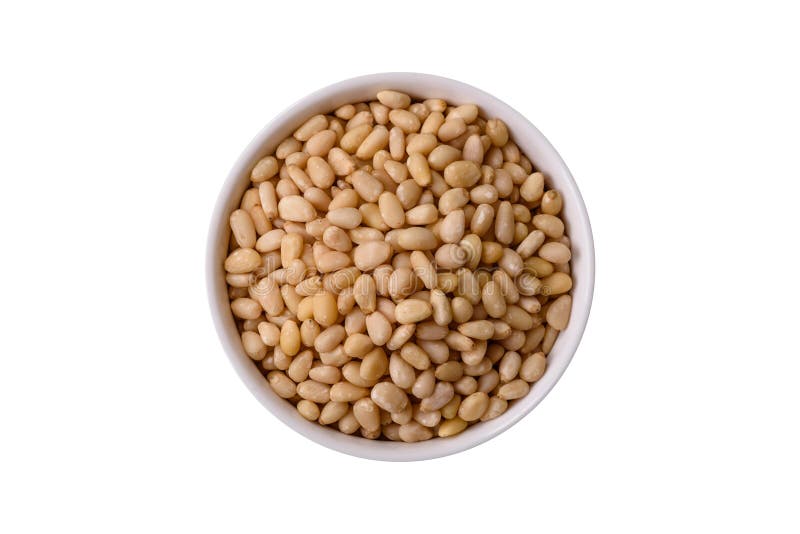 Peeled pine nuts in a bowl on a white background stock images