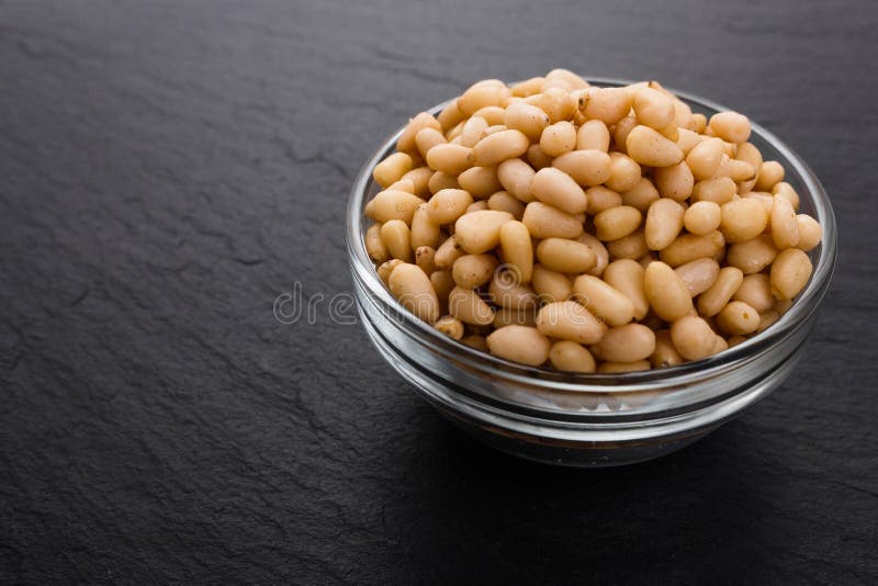 Peeled pine nuts on a rustic background stock photos