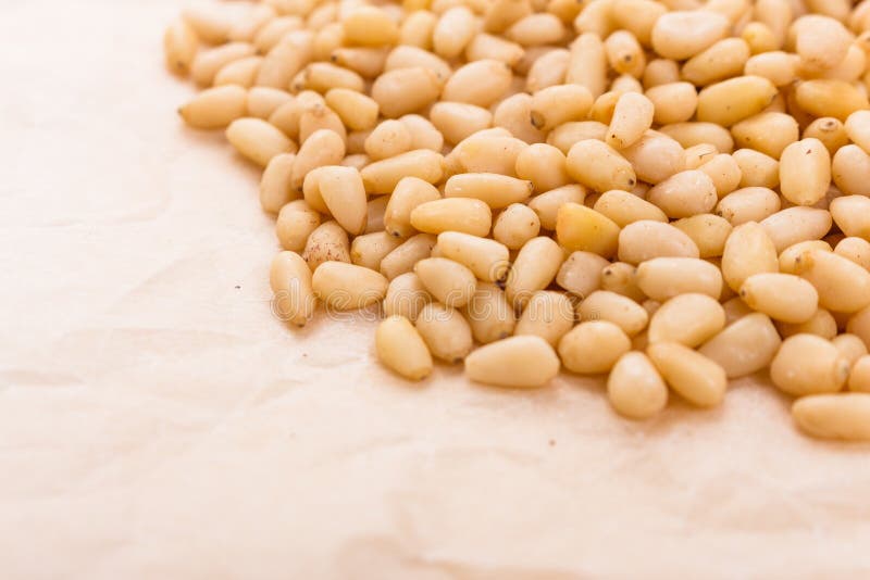 Peeled pine nuts on a rustic background royalty free stock images