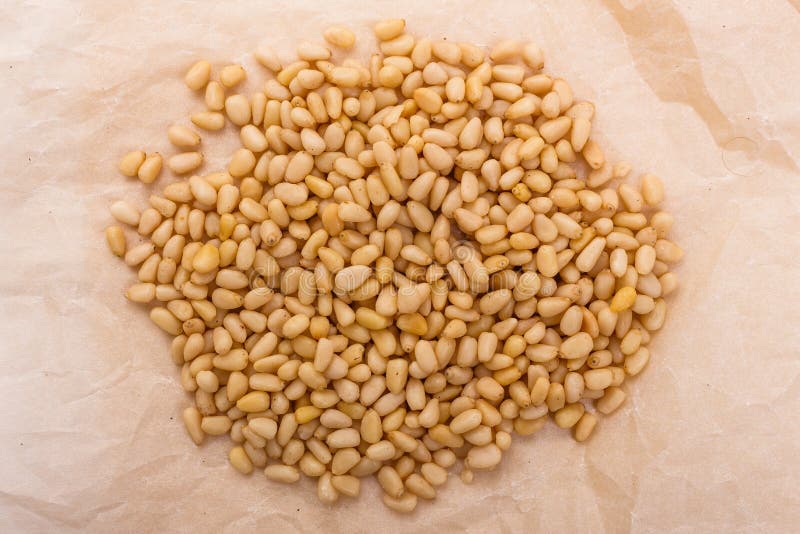 Peeled pine nuts on a rustic background royalty free stock photography