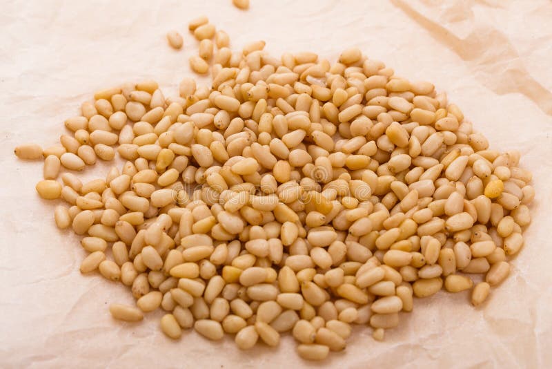 Peeled pine nuts on a rustic background royalty free stock images