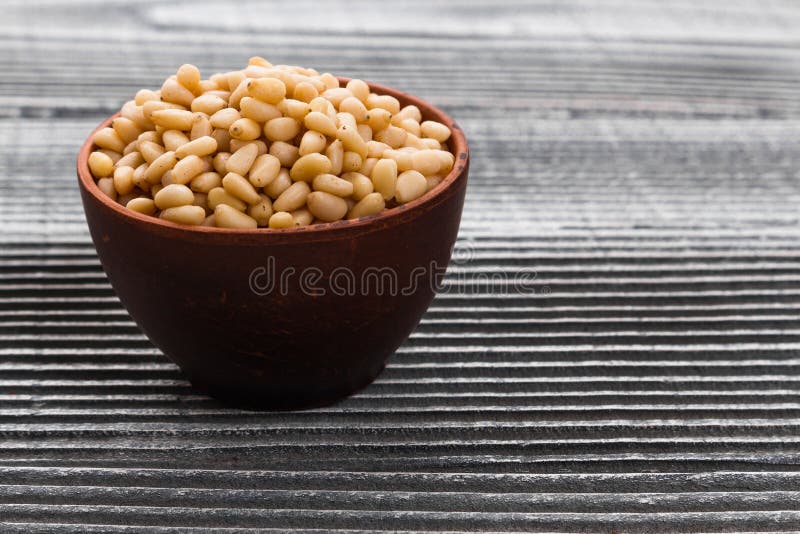 Peeled pine nuts on a rustic background stock images