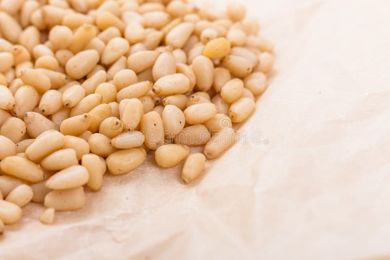 Peeled pine nuts on a rustic background stock photo