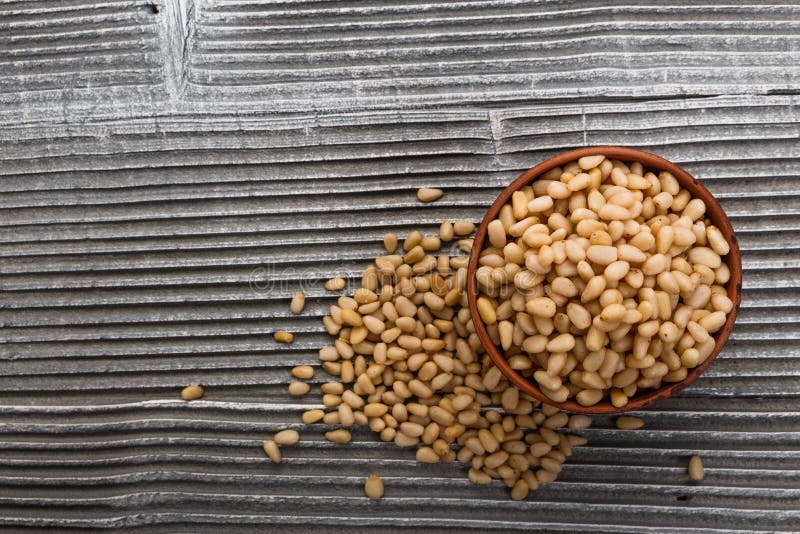 Peeled pine nuts on a rustic background stock image