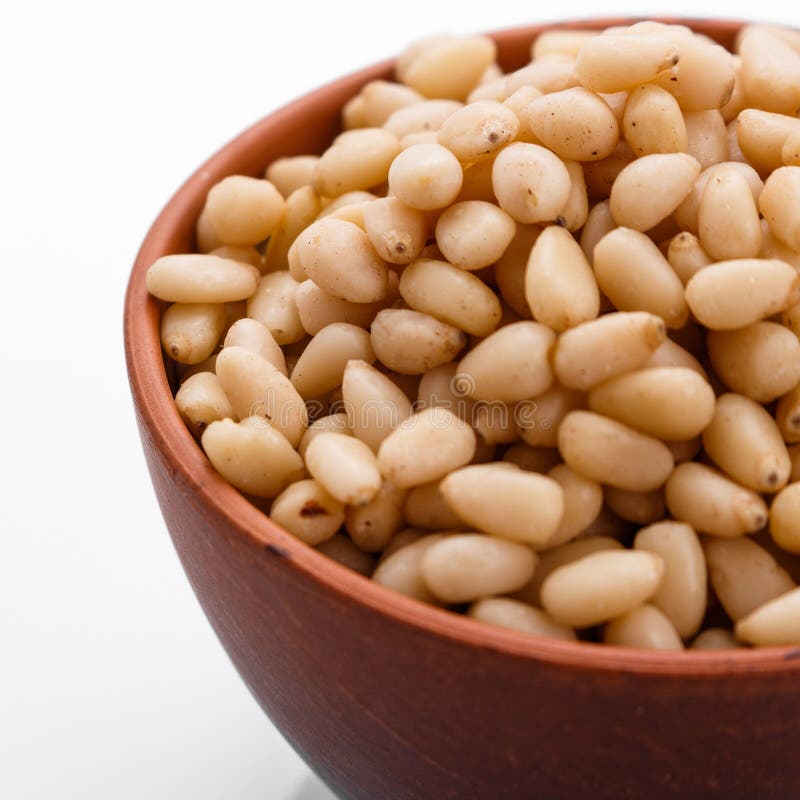 Peeled pine nuts on a white acrylic background stock image