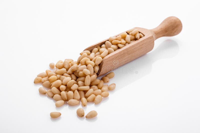 Peeled pine nuts on a white acrylic background royalty free stock photo