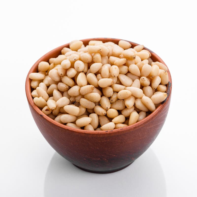 Peeled pine nuts on a white acrylic background royalty free stock photos