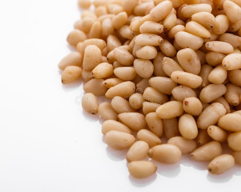 Peeled pine nuts on a white acrylic background stock photography
