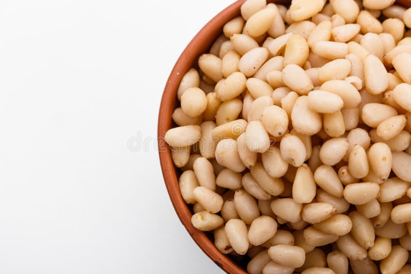 Peeled pine nuts on a white acrylic background royalty free stock photos