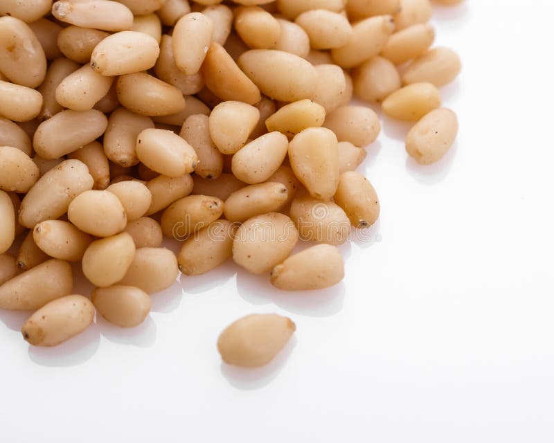 Peeled pine nuts on a white acrylic background stock image