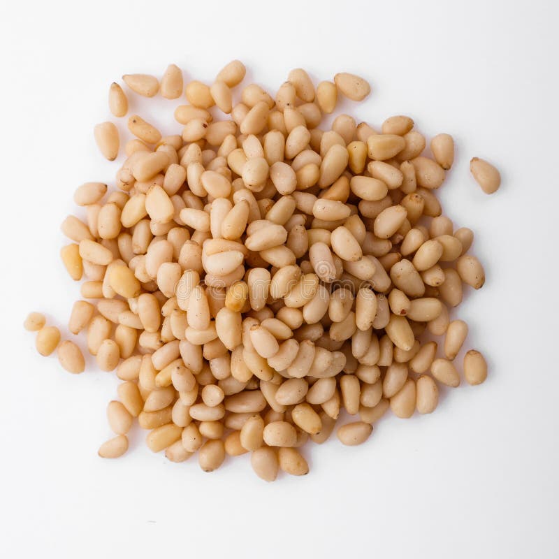 Peeled pine nuts on a white acrylic background royalty free stock images