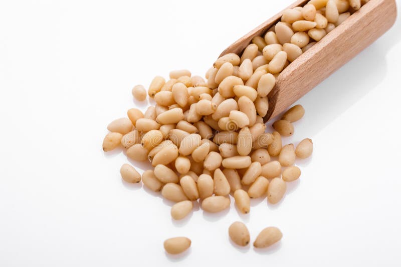 Peeled pine nuts on a white acrylic background stock photography