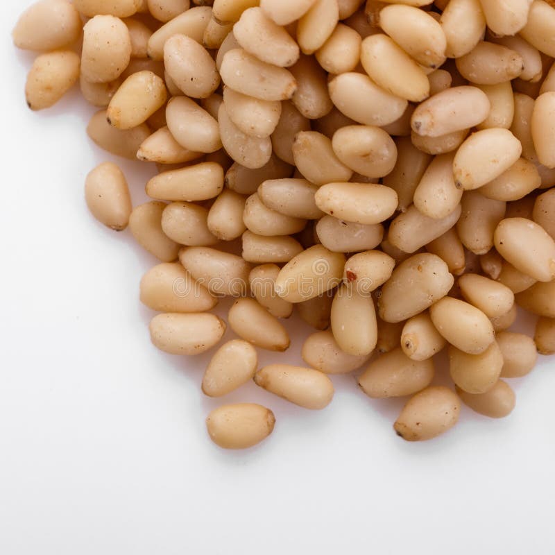 Peeled pine nuts on a white acrylic background stock photos