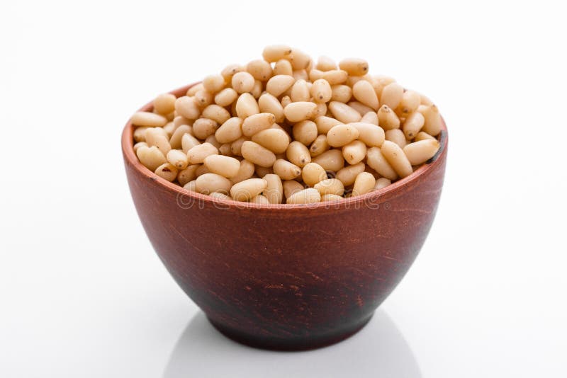 Peeled pine nuts on a white acrylic background stock photography