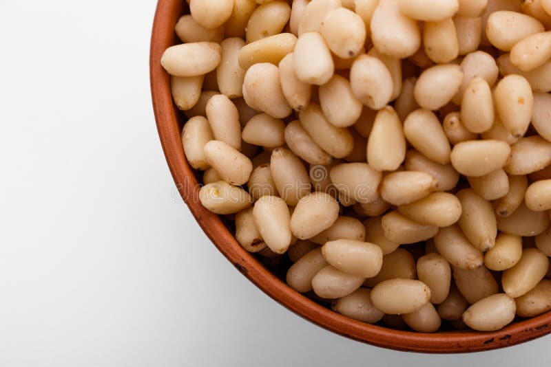 Peeled pine nuts on a white acrylic background royalty free stock photo