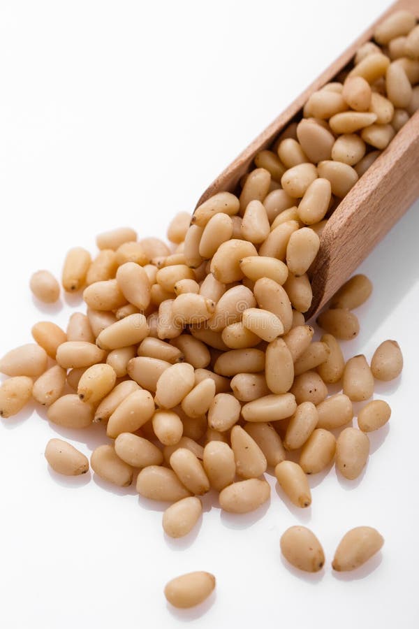 Peeled pine nuts on a white acrylic background stock photos