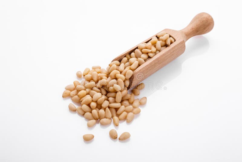 Peeled pine nuts on a white acrylic background royalty free stock images