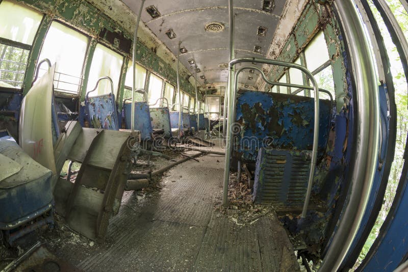 Peeling seats and debris inside abandoned trolley car stock image