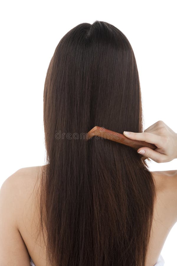 Rear view of a woman combing her long hair. Rear view of a woman combing her long hair